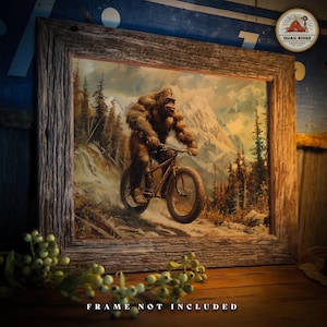 May include: A painting of a Bigfoot riding a mountain bike on a snowy trail. The Bigfoot is brown and furry, and the bike is black with a white frame. The background is a snowy mountain range with trees.