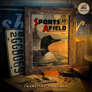 May include: A vintage magazine cover featuring a loon swimming in a lake with a sunset in the background. The magazine is titled "Sports Afield" and the date is September 1934. The cover is framed in a rustic wooden frame.