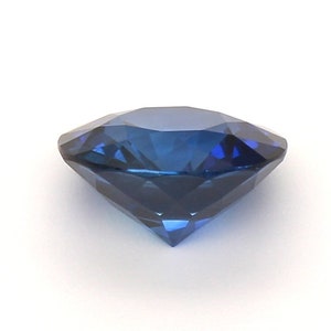 May include: A deep blue gemstone with a round cut and many facets.