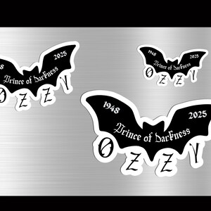 May include: Black bat-shaped stickers with white borders, featuring the text "Prince of Darkness," "1948," "2025," and the letters "OZZY." The stickers vary in size and are displayed on a metallic surface.