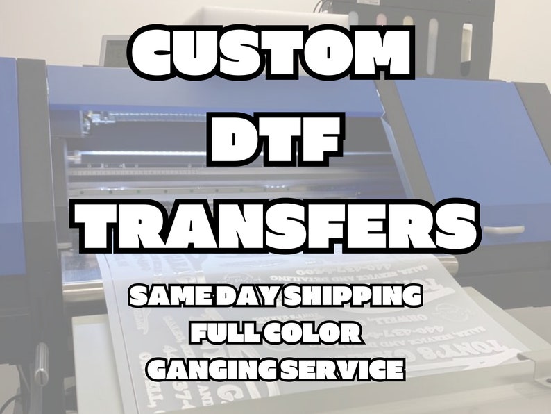 May include: A close-up of a large blue and black digital printing machine with a white sheet of paper in the feed tray. The machine is used to create custom DTF transfers. The text on the paper reads "Same Day Shipping, Full Color, Ganging Service".