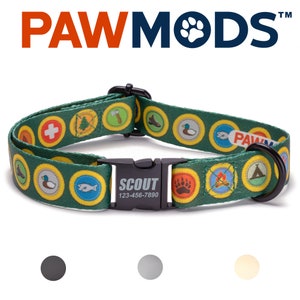 May include: Green dog collar with a Scout theme. The collar features a variety of colorful patches with images of a first aid kit, a tree, an axe, a hiking boot, a duck, a fish, a bear paw print, a campfire, and a tent. The collar has a black buckle with the word "SCOUT" and the phone number 123-456-7890.