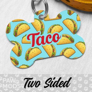 May include: A blue bone-shaped dog tag with a pattern of yellow tacos and the word "Taco" in red. The tag is two-sided.