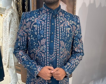 May include: A teal blue long-sleeved kurta with a floral pattern in pink, white, and gold. The kurta has a mandarin collar and a button closure.