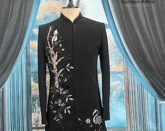 Puede incluir: Chaqueta formal negra con bordados intrincados. La chaqueta presenta un cuello mandarín y mangas largas. El lado izquierdo está adornado con un diseño de árbol y flores, mientras que el lado derecho tiene un diseño de pájaro y flores. El texto "Golden Attire" y "KC 5023" son visibles.