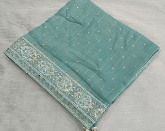 May include: A light blue scarf with a gold embroidered border and a tassel. The scarf has a dotted pattern.