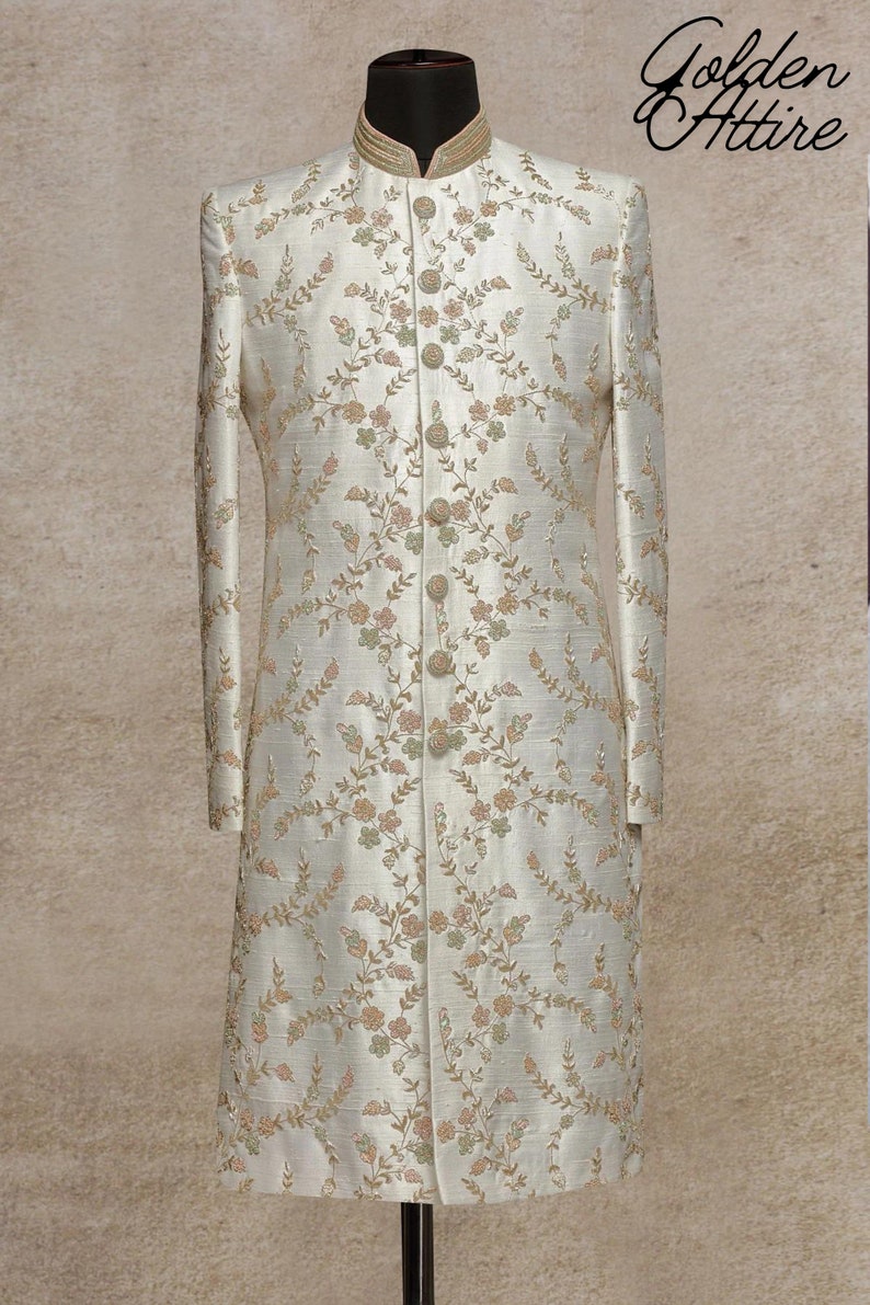 K&ouml;nnte beinhalten: Ein wei&szlig;es, lang&auml;rmliges Kleidungsst&uuml;ck mit einem Stehkragen und einem Blumenmuster. Das Kleidungsst&uuml;ck hat eine Knopfleiste vorne und ist aus einem seidenartigen Stoff gefertigt.