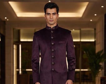 May include: A formal, dark burgundy velvet jacket with a mandarin collar and button-down front. The long-sleeved jacket has a tailored fit and a small pocket on the left side. The jacket is part of a formal wear collection.