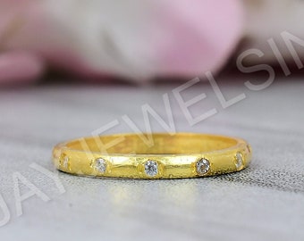 May include: A thin gold band ring with small diamonds set in the band.