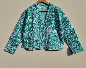 Könnte beinhalten: Eine grüne gesteppte Jacke mit weißem Blumendruck und Knopfleiste. Die Jacke hat zwei Taschen auf der Vorderseite.