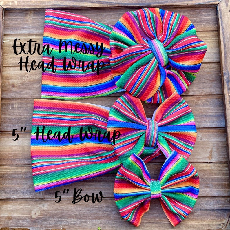 May include: Three colorful striped fabric headbands and bows. The largest headband is labeled "Extra Messy Head Wrap". The medium headband is labeled "5" Head Wrap". The smallest bow is labeled "5" Bow".