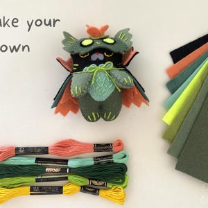 Halloween-themed swamp Cat plush made from a felt sewing pattern, displayed with materials.