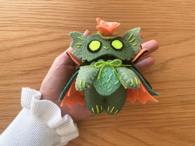 Stuffed halloween cat plush toy, handcrafted from felt, ideal for gothic, witchy, or spooky home decor. Close-up of a soft swamp cat plush using a beginner-friendly PDF pattern, with cute embroidered details.