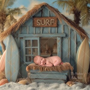 Könnte beinhalten: Ein neugeborenes Baby schläft auf einem Bett in einer blauen Holzhütte am Strand mit einem Strohdach. Die Hütte hat ein Schild mit der Aufschrift "SURF" und ist von Palmen und Surfbrettern umgeben.