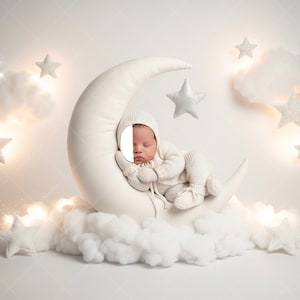 May include: A newborn baby in a white knitted outfit, including a hat, mittens, and booties, is nestled on a crescent moon prop. The scene is decorated with fluffy white clouds, sparkling stars, and soft lighting, creating a dreamy, celestial theme.