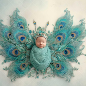 May include: A newborn baby wrapped in a teal blanket, posed as the body of a butterfly. The wings are made of teal peacock feathers with blue and brown accents. The baby wears a matching cap with a floral crown. The background is a light blue.