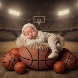 May include: A sleeping baby in a beige knitted outfit and hat rests on a basketball. The baby is nestled on a fluffy, light-coloured surface, surrounded by several basketballs. The background shows a basketball arena.
