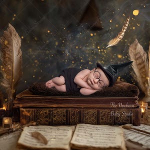 Puede incluir: Un bebé recién nacido con un atuendo negro, un sombrero de mago y gafas redondas, durmiendo sobre una pila de libros antiguos. La escena está decorada con plumas, velas y destellos dorados, creando un tema mágico.
