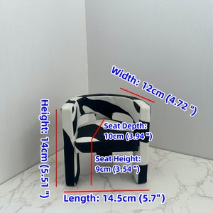 May include: A small black and white patterned armchair with a seat depth of 10cm (3.94 inches), a seat height of 9cm (3.54 inches), a width of 12cm (4.72 inches), a length of 14.5cm (5.7 inches), and a height of 14cm (5.51 inches).