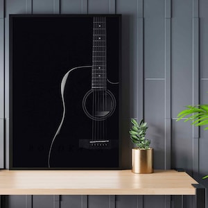 以下が含まれることがあります： 黒いフレームに入ったアコースティックギターの白黒写真。ギターは黒い背景にシルエットになっている。