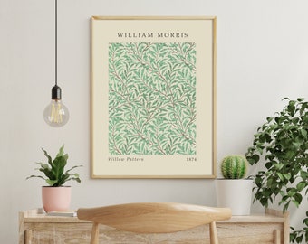 May include: A framed print of a vintage William Morris wallpaper pattern called "Willow Pattern" featuring a repeating design of green leaves and branches on a cream background. The print includes the text "William Morris", "Willow Pattern", and "1874".
