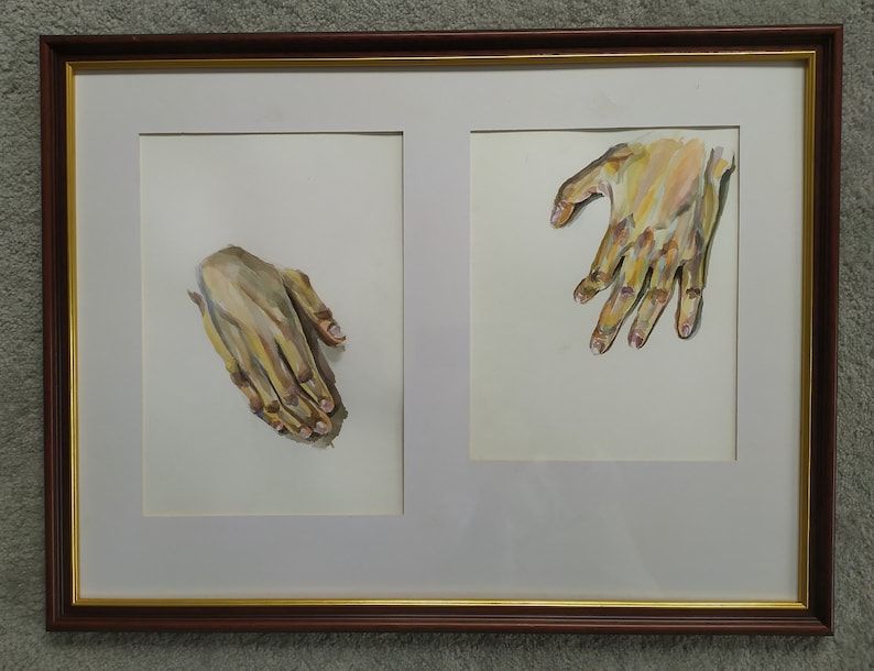 May include: Two framed watercolor paintings of hands. The left painting shows a hand with fingers curled inward, while the right painting shows a hand with fingers spread out.