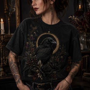 Lifestyle mockup showing a woman wearing a washed black T-shirt printed with the gothic raven and black rose design.