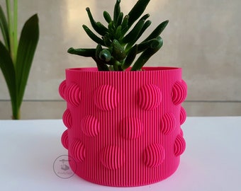 Simpatica copertura per fioriera rosa con strisce verticali e dettagli a bolle. Decorazione ideale per cactus, piante grasse e altre piante da interno