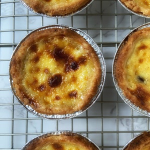 Picture of baked Pasteis de Nata "Portuguese Custard Tart" with a crispy crust and a delicious custard with blisters on top product of High temperature in the oven.