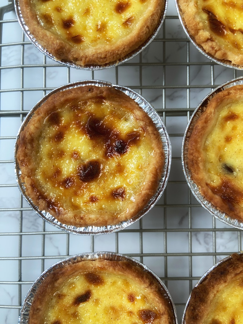 Picture of baked Pasteis de Nata "Portuguese Custard Tart" with a crispy crust and a delicious custard with blisters on top product of High temperature in the oven.