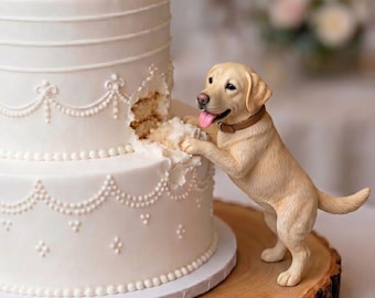 Puede incluir: Un pastel blanco de varios niveles con detalles de glaseado presenta una figura de un perro labrador amarillo de pie sobre sus patas traseras, con las patas delanteras sobre el pastel, pareciendo haber mordido el costado del pastel.