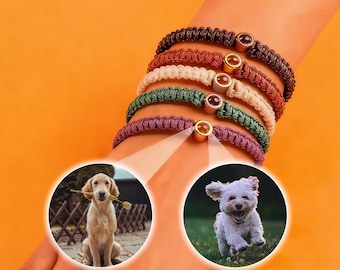 May include: A collection of six macrame bracelets in various colors, including brown, red, cream, green, and purple. Each bracelet features a gold-colored bead with a brown stone. Two circular images of dogs are in the lower portion of the image.