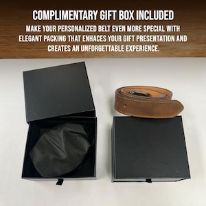 May include: A tan leather belt coiled next to a black gift box. The box is open, revealing a black fabric pouch inside. Text at the top reads: COMPLIMENTARY GIFT BOX INCLUDED. MAKE YOUR PERSONALIZED BELT EVEN MORE SPECIAL WITH ELEGANT PACKING.