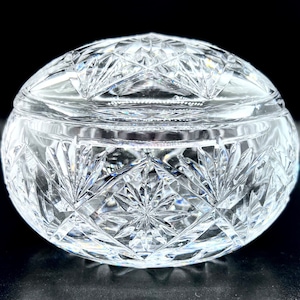 Könnte beinhalten: Eine runde Schatulle aus klarem Glas mit einem komplizierten geschliffenen Glasdesign.
