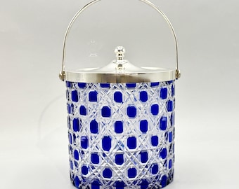 May include: A cylindrical ice bucket featuring a deep blue glass body with a clear diamond-cut pattern. The container includes a polished silver-tone metal lid with a central knob handle and a matching arched swing handle attached to the sides.