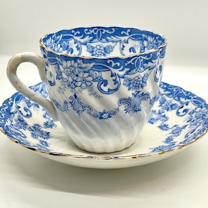 Antike blaue & weiße Porzellan-Teetasse und Untertasse: Handbemalter Blumenwirbel, c1900