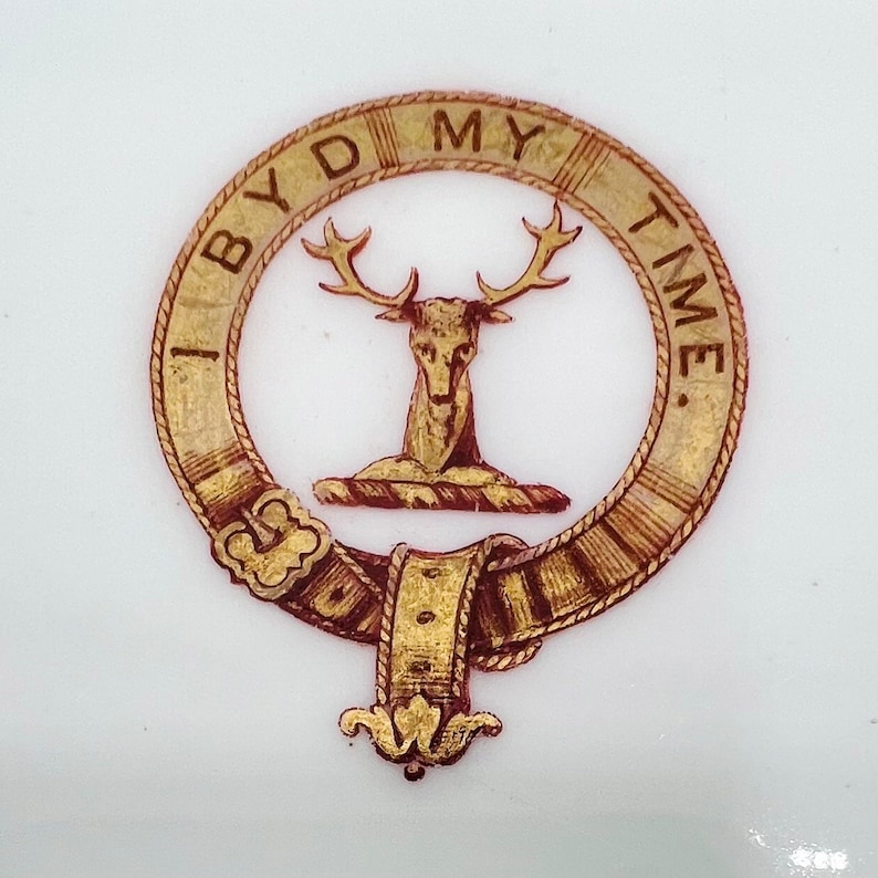 May include: A gold and red crest with a stag and the text "I BYD MY TIME."