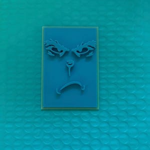 May include: A teal rectangular stamp featuring a face design. The face has stylized eyebrows, a nose, and a downturned mouth, all in teal. The stamp is set on a light green base.