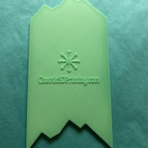 May include: A light green, textured, 3D-printed object with a mountain-like top and a jagged bottom edge. A snowflake design is in the center, and the text "Chaotic3DPrinting.com" is printed below the snowflake.
