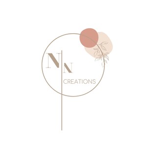 Puede incluir: Un diseño de logotipo con las letras "NN" en un círculo, con el texto "CREATIONS" debajo. El círculo está rodeado por una línea marrón y una forma abstracta rosa y beige con una rama estilizada con hojas.