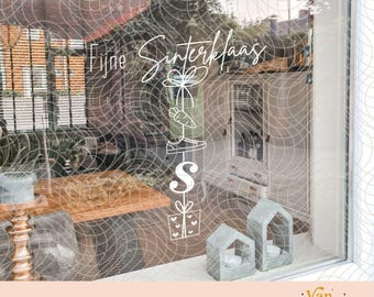 May include: A white vinyl window decal featuring the text Fijne Sinterklaas in a cursive script, accompanied by a vertical stack of line art icons including a carrot, a shoe, the letter S, and a gift box with hearts, applied to a glass pane.