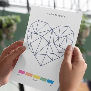 May include: A white mood tracker with a geometric heart design in blue. The heart is divided into sections with a color scale for tracking mood: good, neutral, and bad.
