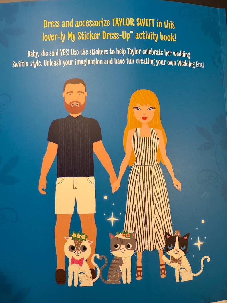 May include: An activity book with the text "Dress and accessorize TAYLOR SWIFT in this lover-ly My Sticker Dress-Up activity book!" The image features illustrations of a couple, three cats, and sparkling stars on a blue background.