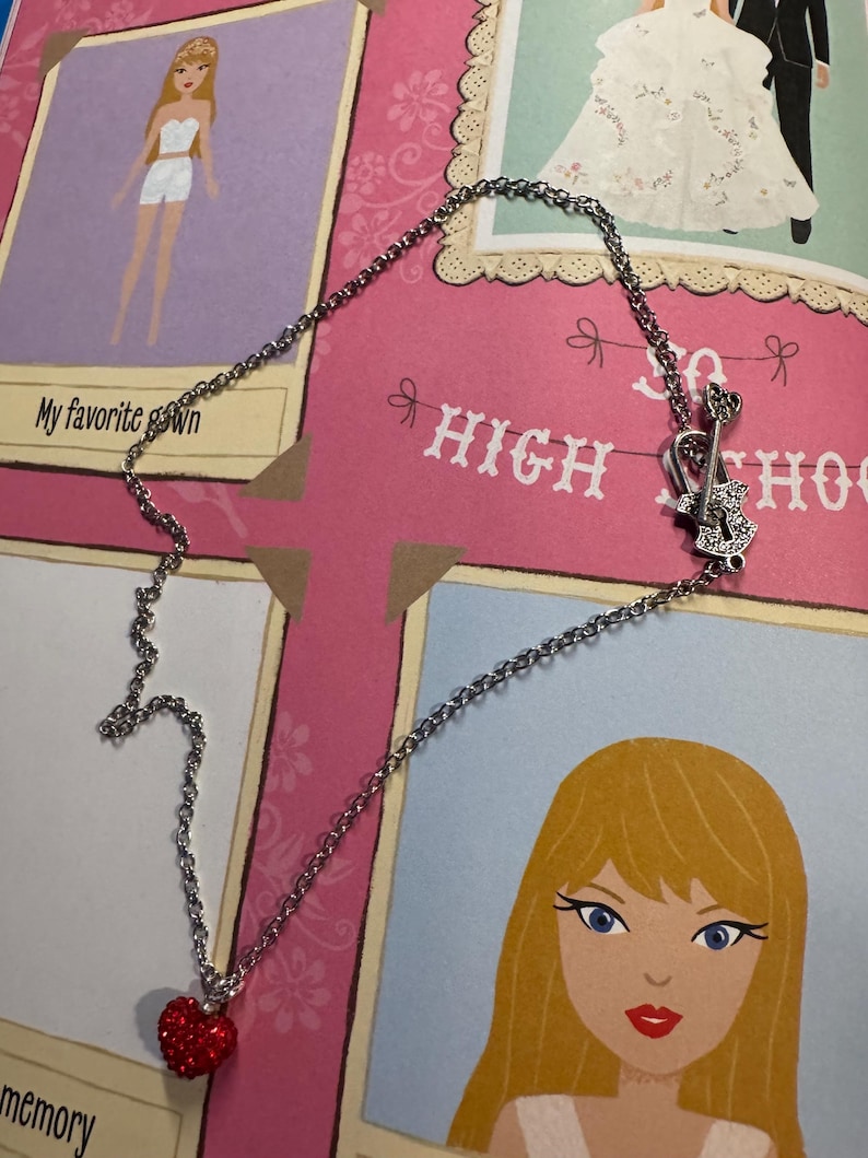 May include: A silver necklace featuring a red heart pendant and a guitar-shaped charm. The necklace is set against a pink backdrop with the words "HIGH SCHOOL" and illustrations of a bride and a cartoon girl.