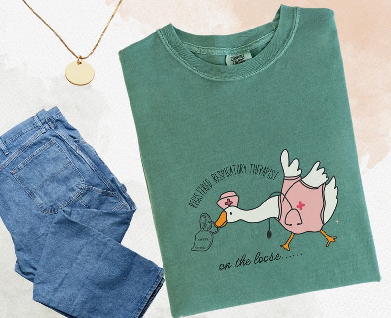 May include: A green t-shirt with a cartoon goose wearing a nurse's hat and holding a face mask. The text on the shirt reads "Registered Respiratory Therapist on the loose..."