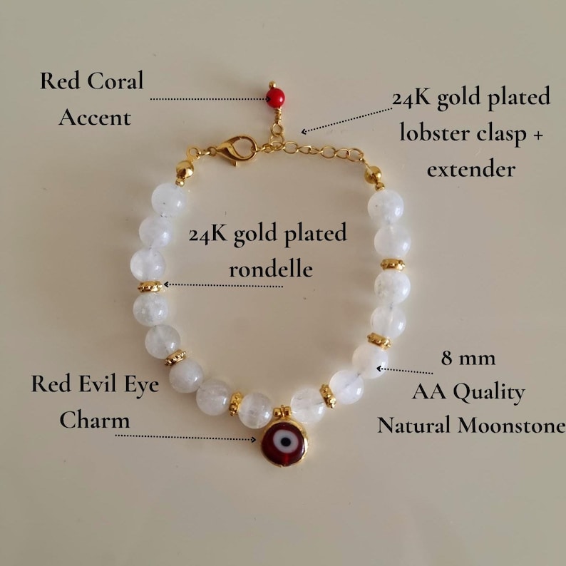 May include: A bracelet featuring 8 mm AA quality natural moonstone beads, 24K gold plated rondelles, a red evil eye charm, a red coral accent, and a 24K gold plated lobster clasp with an extender. Text labels identify these components.