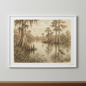 A framed pencil sketch of a wetland scene with a heron, cypress trees, and lily pads, displayed on a light wood surface against a white wall.