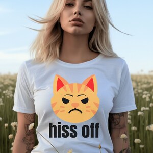 May include: White t-shirt with a cartoon cat face and the text "hiss off".