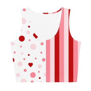 Puede incluir: Un top blanco de tirantes con una longitud recortada. El lado izquierdo del top presenta un patr&oacute;n de lunares rojos y rosas con un peque&ntilde;o coraz&oacute;n rojo. El lado derecho del top presenta rayas verticales rojas y rosas alternas.