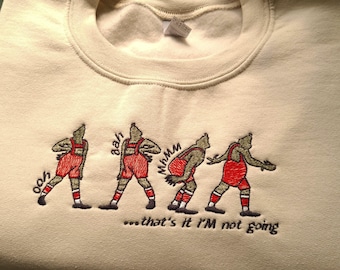 May include: A beige sweatshirt with an embroidered design of five figures in various stages of lifting a heavy object. The figures are green with red shorts and white socks. The text "...that's it I'M not going" is embroidered below the figures.